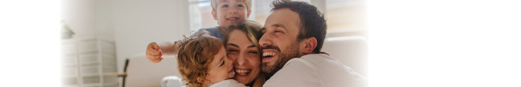 Local San Bernardino family hugging in their home